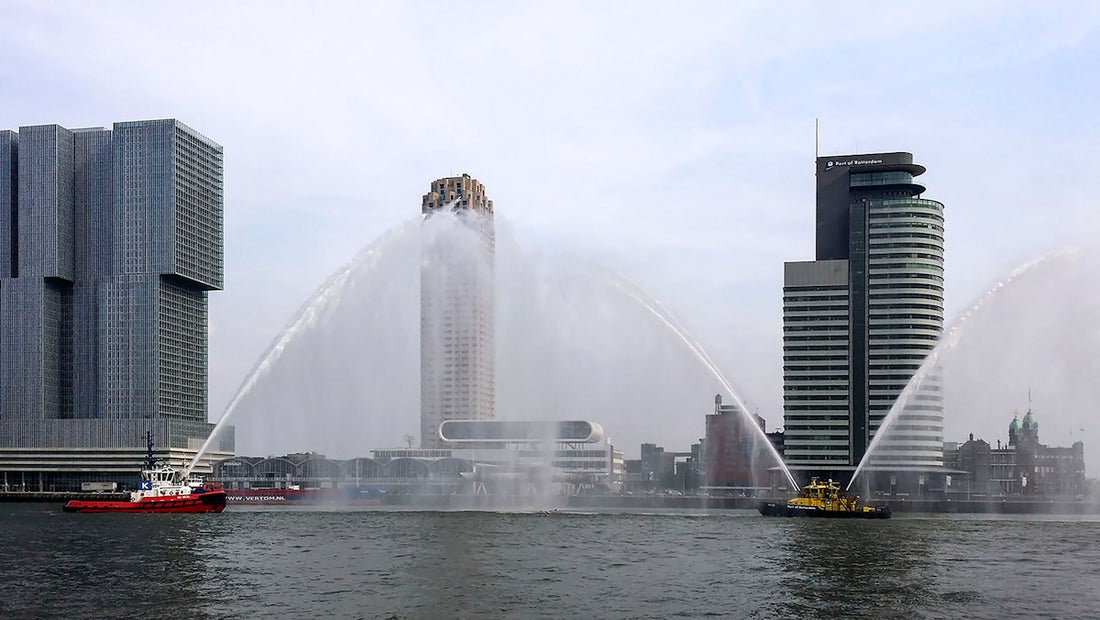 Two boats spray water with city skyline background