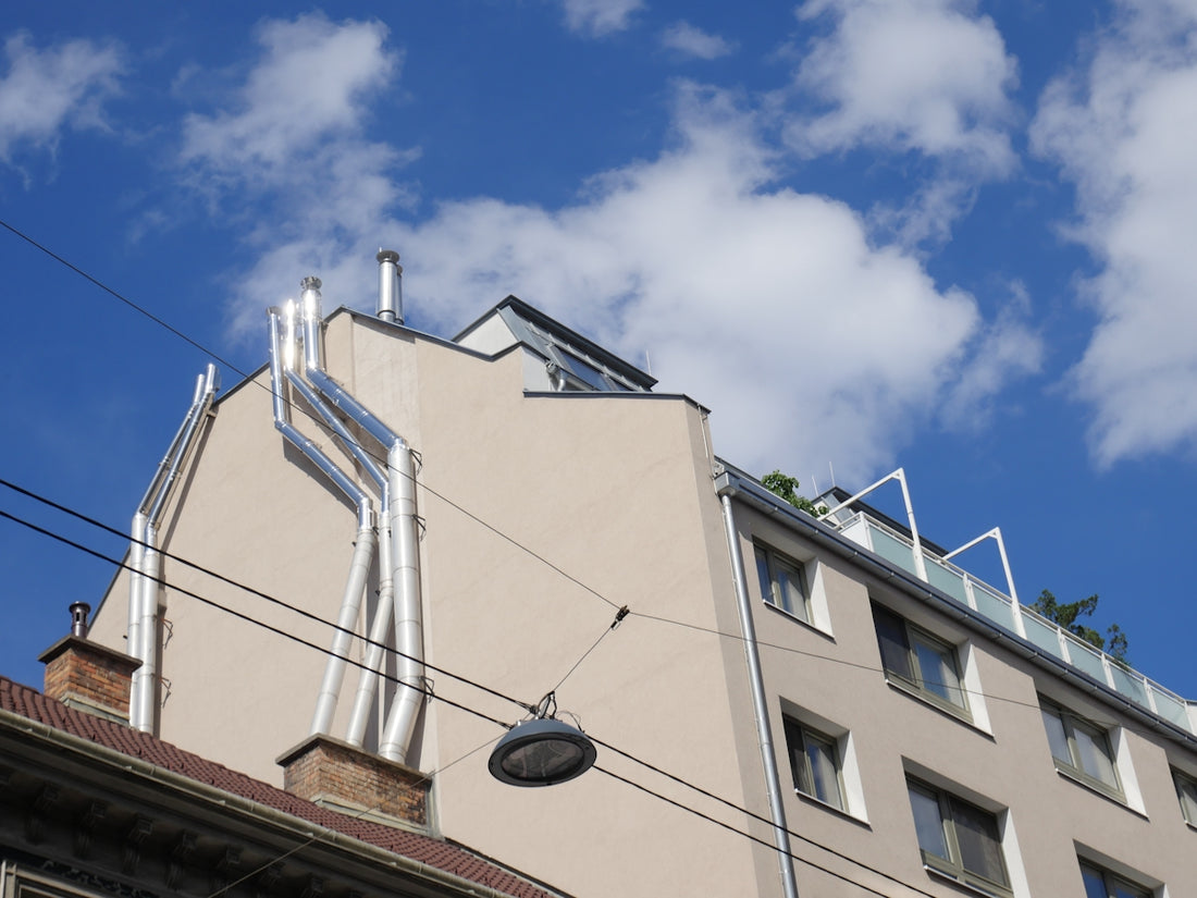 Shiny metal pipes on a building facade under blue sky